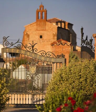 Entrance gate to Termantia estate with an historic church in the background, showcasing the rich cultural heritage of the Bodega Numanthia vineyards in the Toro region, Spain.